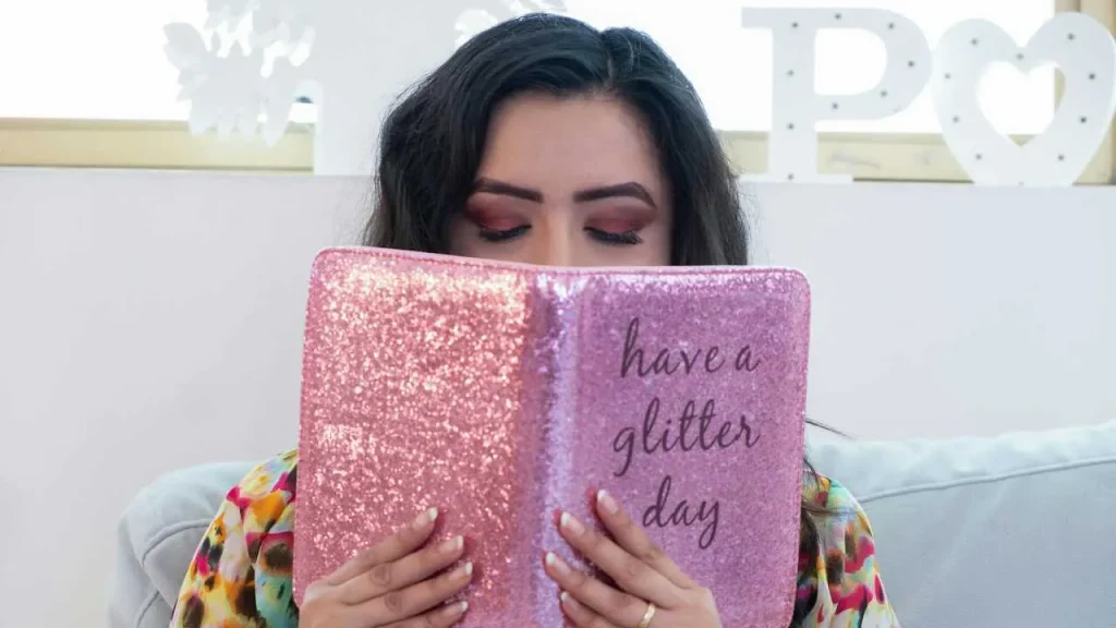 A lady reading a book titled have a glitter day