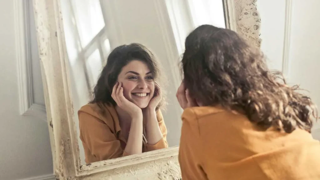 Lady smiling at herself in the mirror