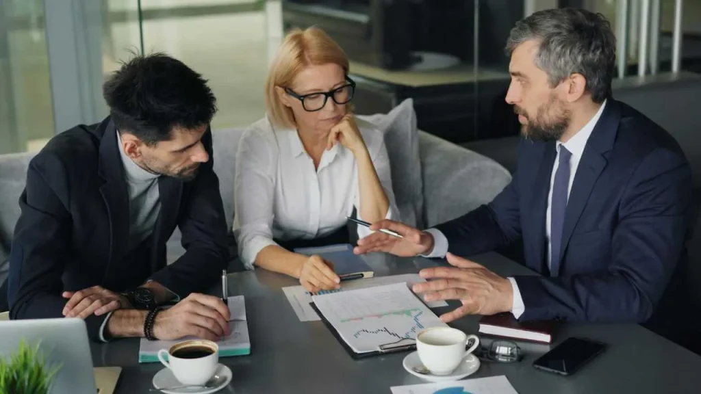 A team of two men and a lady discussing over a desk