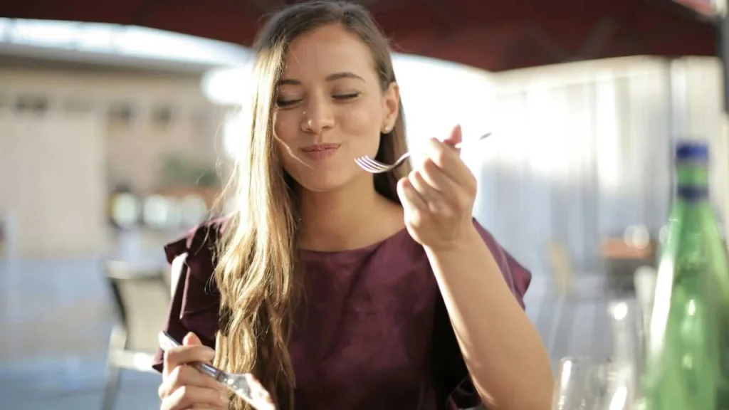 A lady using all her senses to enjoy her meal