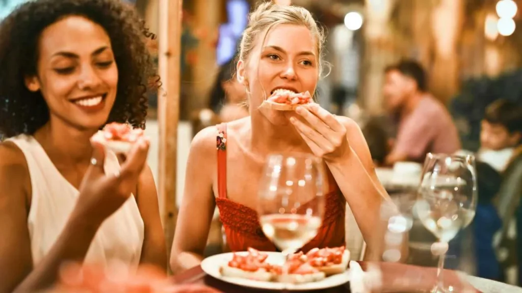 Two ladies chewing their food thoroughly as a step in practicing mindful eating