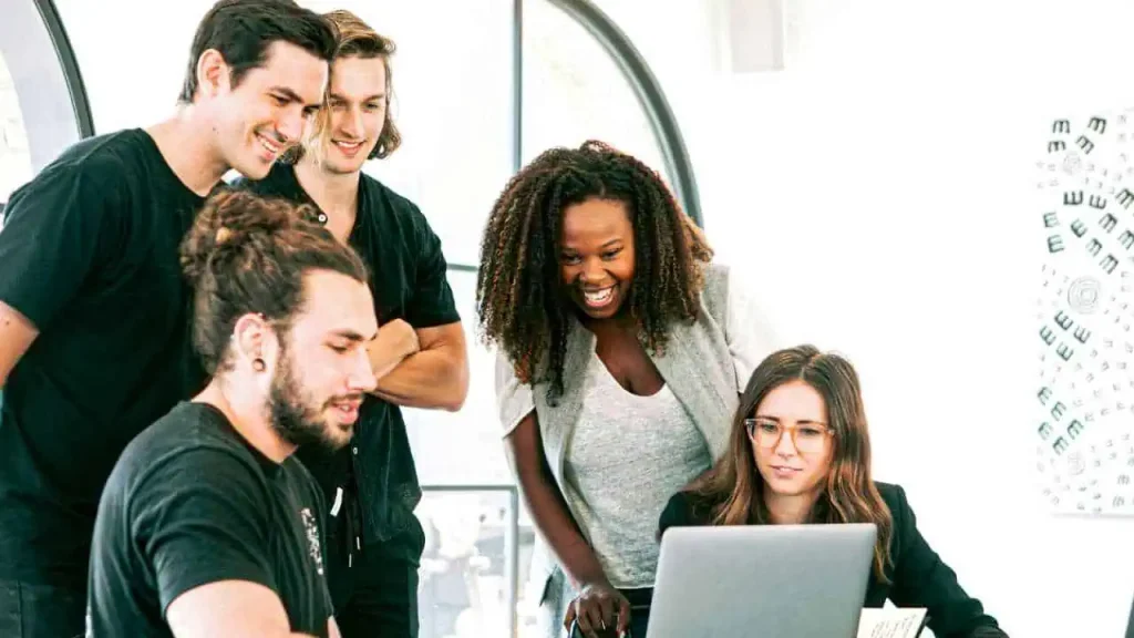 A group of employees working together on a project on a laptop