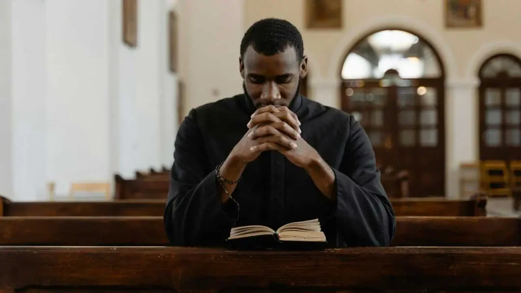 A man in dark sleeves praying representing how to stop worrying and start living