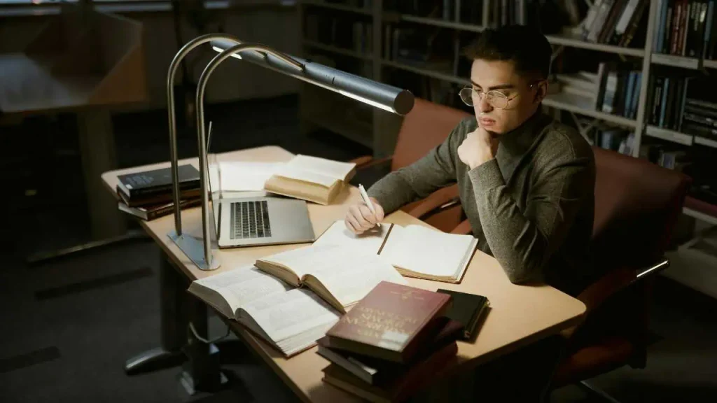 A man studying with a lamp representing how to stop procrastinating