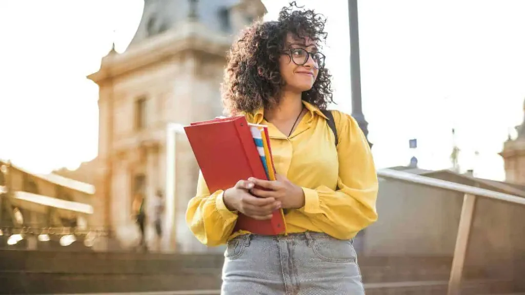 A lady on yellow sleeves holding a red book