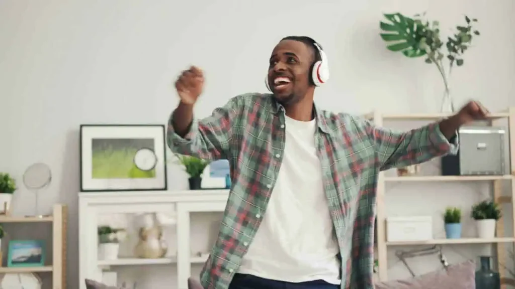 A man on headphone dancing representing how to transform your life with positive thoughts
