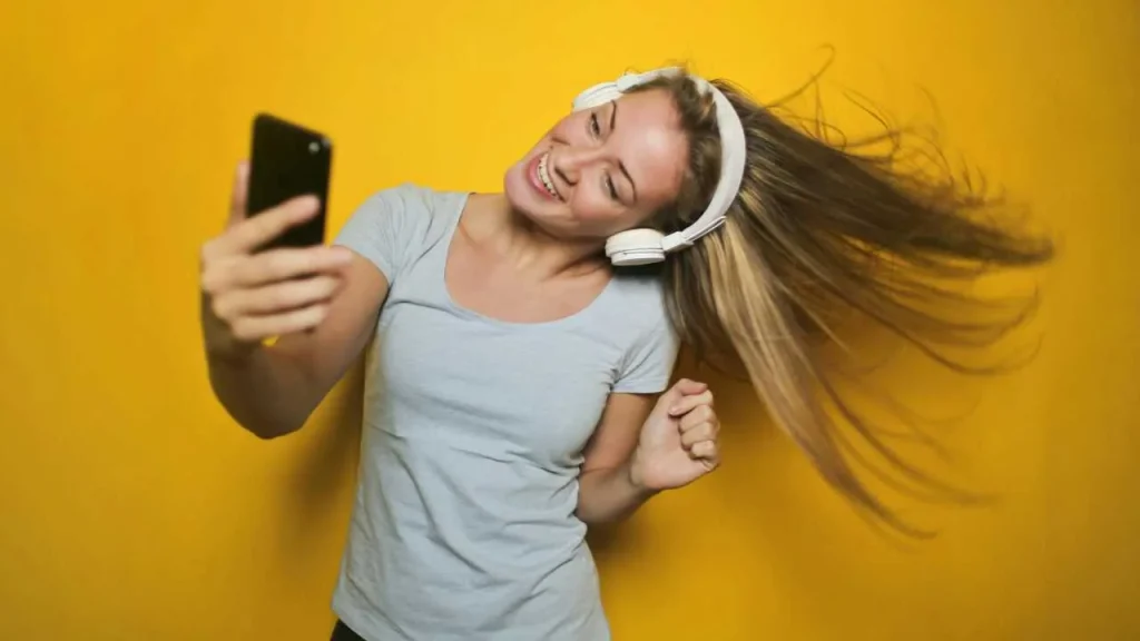 A lady dancing with a headphone on representing self-love quotes