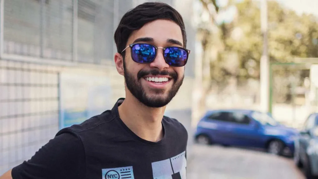 A man on shades smiling representing self-love quotes