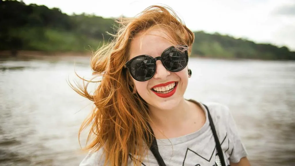 A happy lady smiling with black shades on