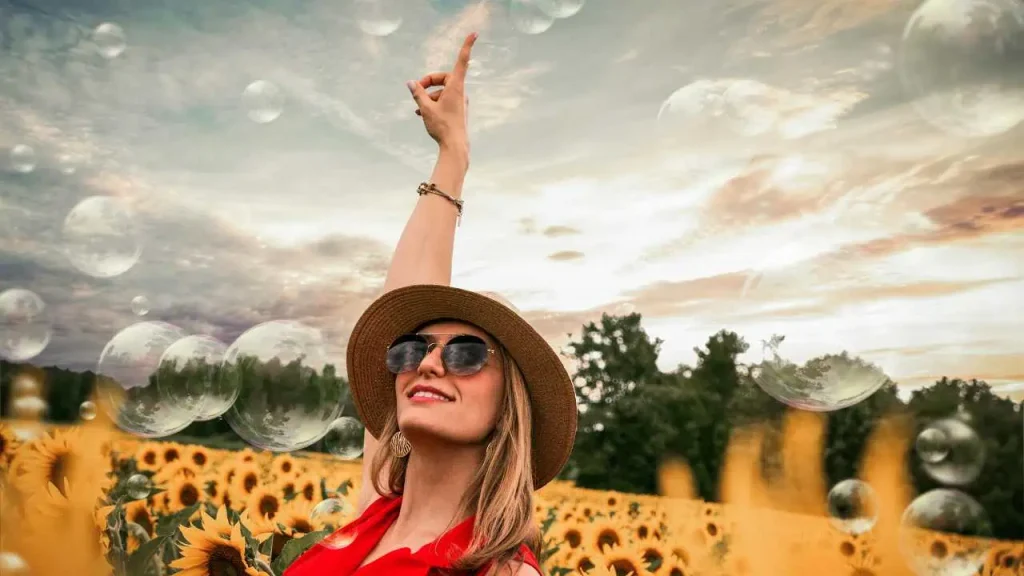 A lady on brown hat in the midst of flowers