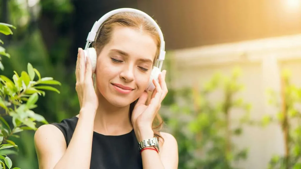A lady peacefully listening to music on an headphone