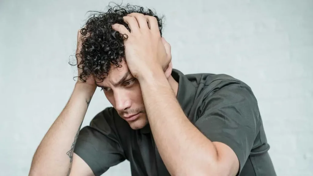 A man looking insecure with hands on his head