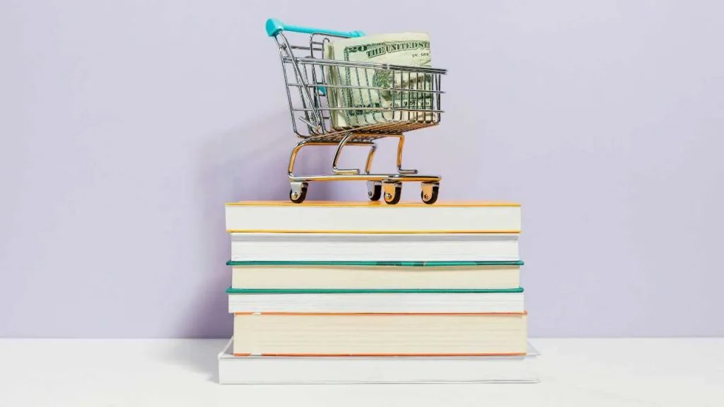Pile of books, cart and dollars
