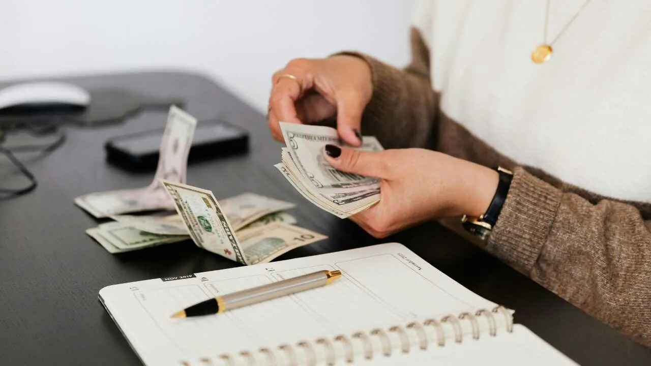 A hand calculating money depicting my candid advice on making money the right way