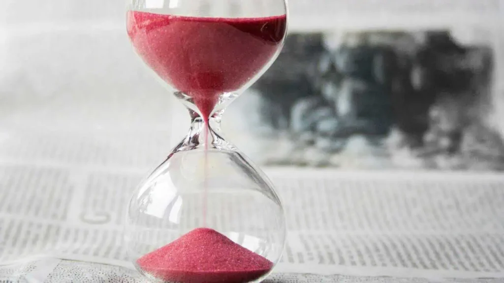 An hour glass containing red sand