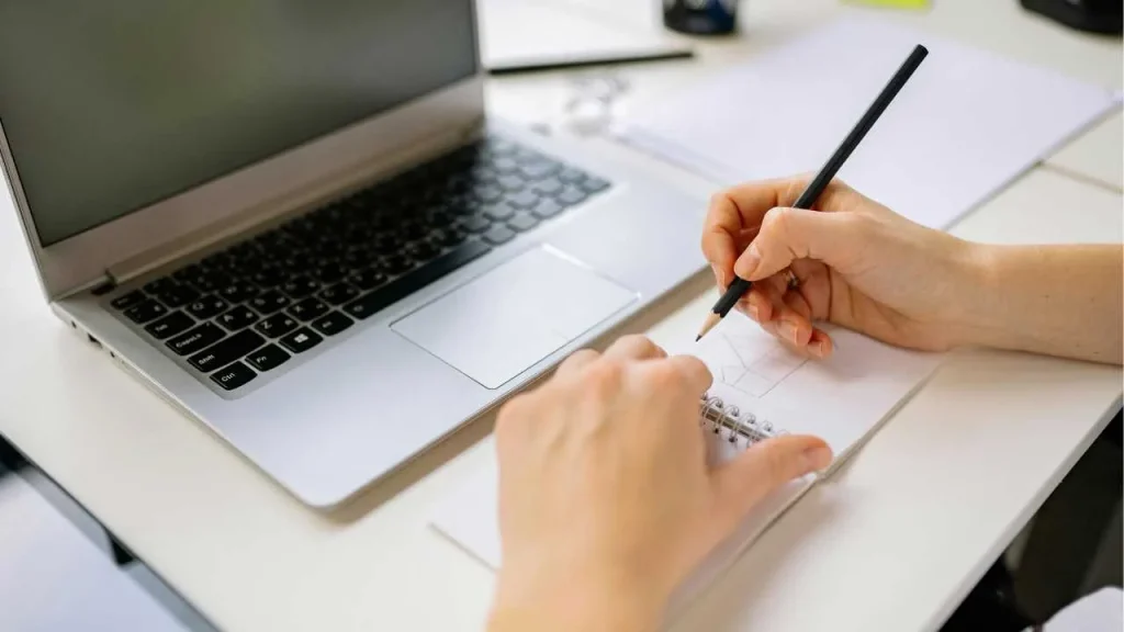 A laptop and a note book on a table