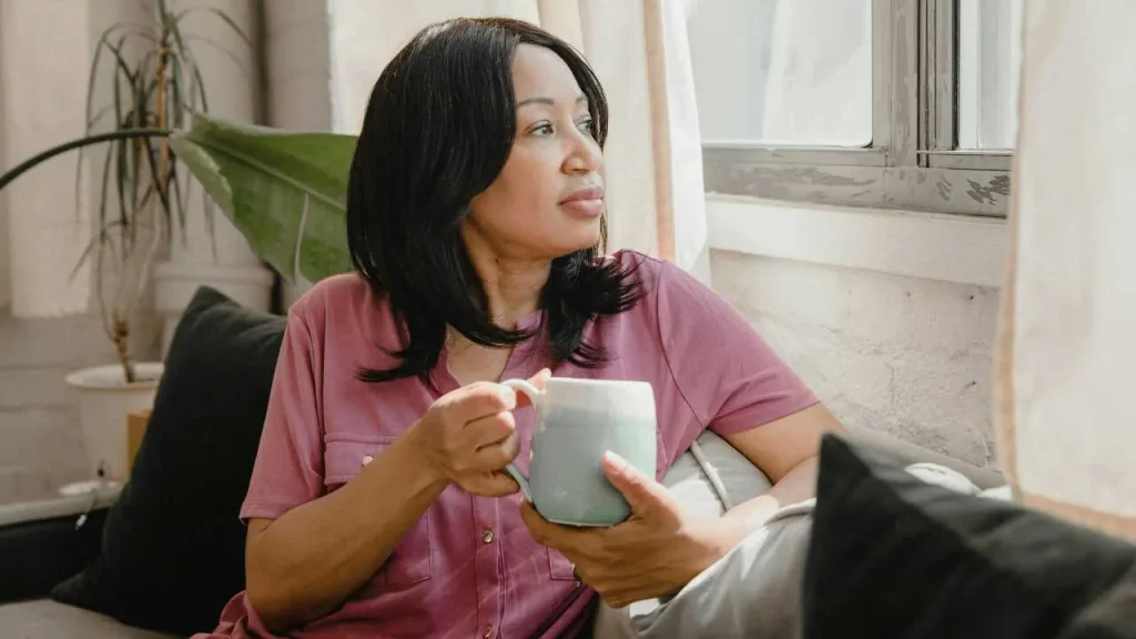 A lady holding a mug depicting waking up early can change your life