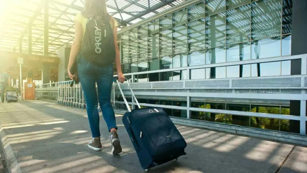 A lady with a traveling bag depicting how to enjoy life and be happy