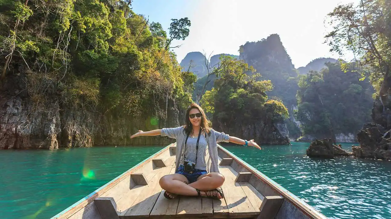 A joyful lady sitting on a canoe on a River depicting how to enjoy life