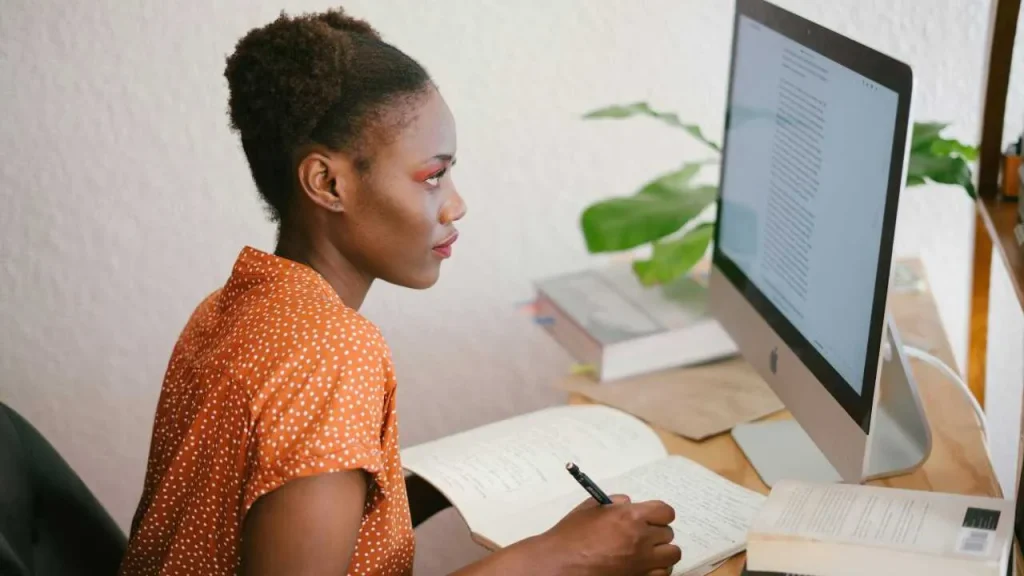 A lady writing from a computer