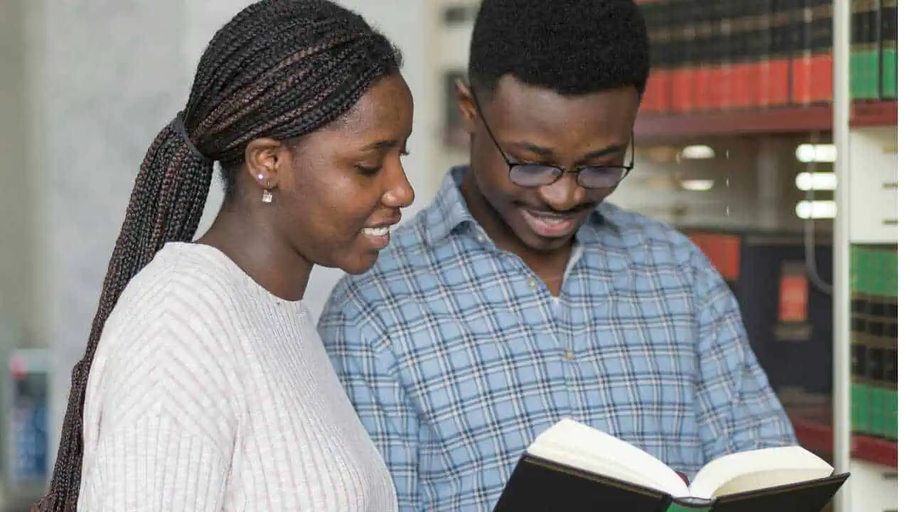 Two persons joyfully studying the Bible depicting Biblical quotes on happiness