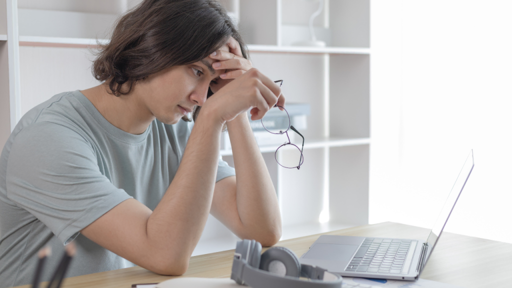 A lady on a grey t-shirt with her head bow down depicting ways to boost motivation
