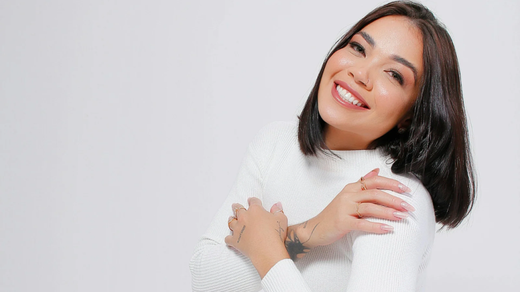 A lady in white, having her hands wrapped around herself, which depicts how to be content alone