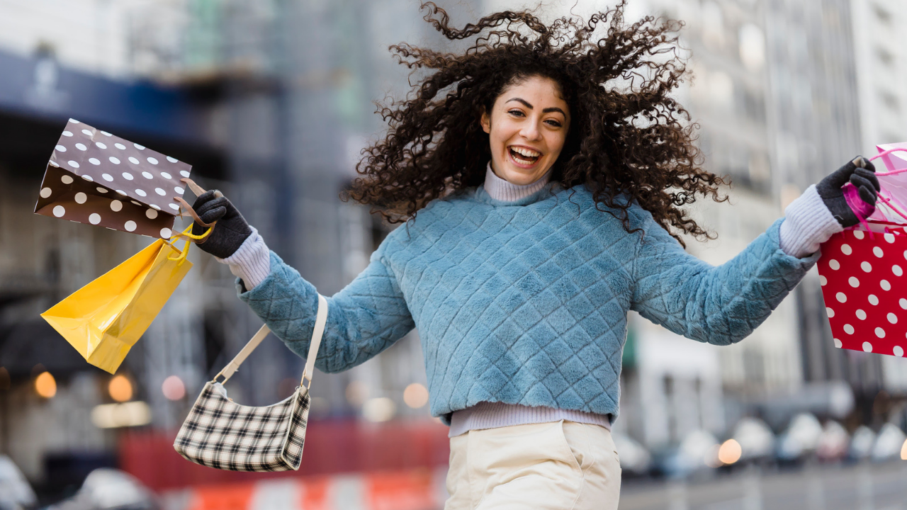 A joyful lady holding shopping bags depicting how to be content alone