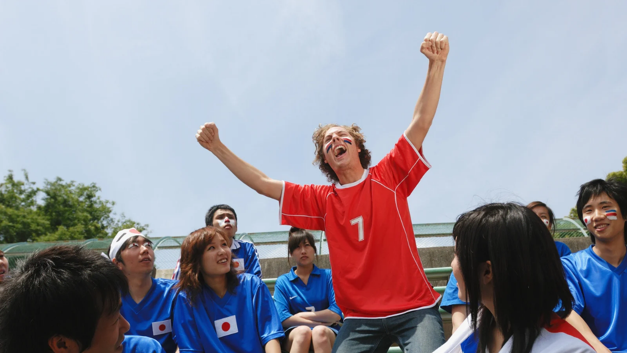 How to Stop Being a People Pleaser and Start Living in God’s Approval A boy on red shirt raising both hands amongst others on blue shirt depicting how to stop being a people pleaser