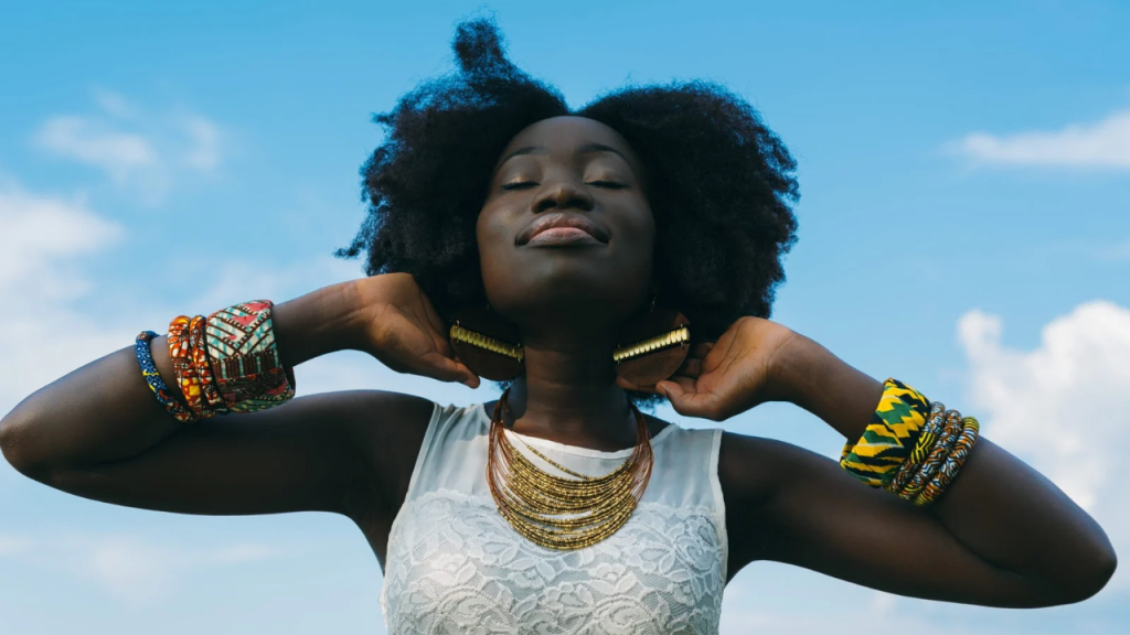 An African American woman having her hands raised up