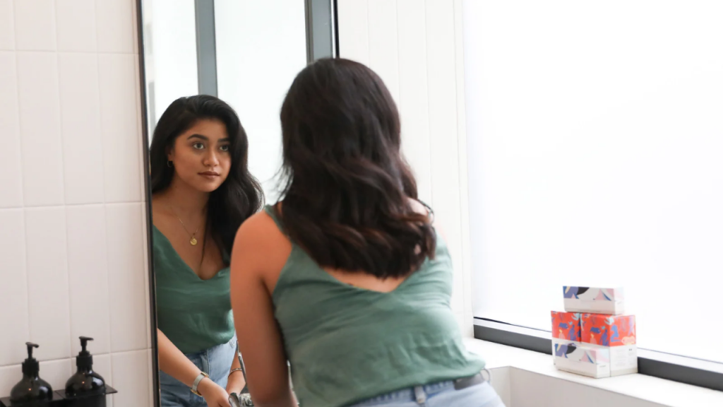 A lady starring into a mirror depicting how to Journey Back to Your Strengths 