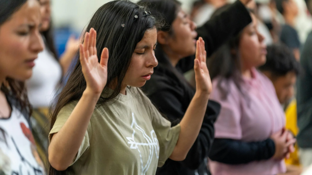 A lady lifting up her hands in worship depicting you're God's workmanship 