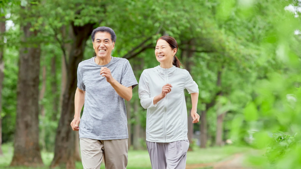 Two elderly person running on an open track 