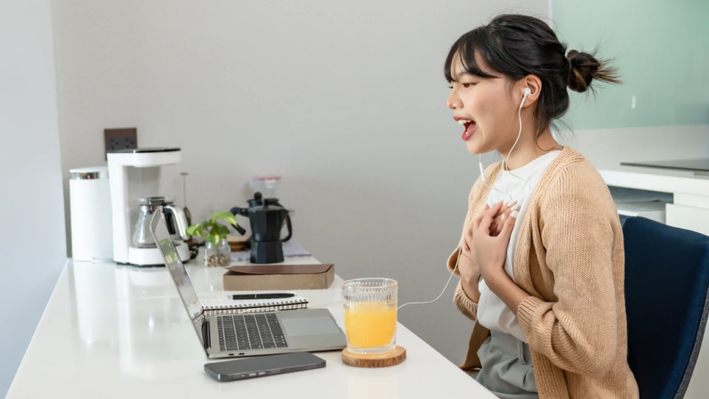 A lady speaking to a camera, putting on an ear piece depicting how to build a routine 