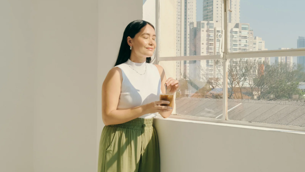 A lady standing by the window depicting how to start seeking God first